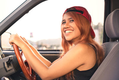 Portrait of smiling young woman sitting in car