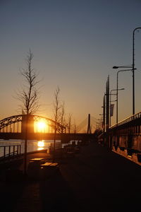 Bridge over street against sky during sunset