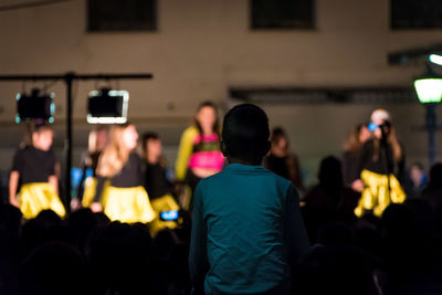Rear view of people photographing at night
