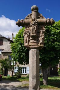 Statue by historic building against sky