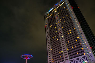 Low angle view of illuminated skyscraper against sky at night