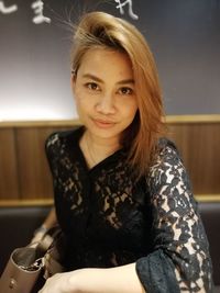 Portrait of smiling young woman sitting outdoors