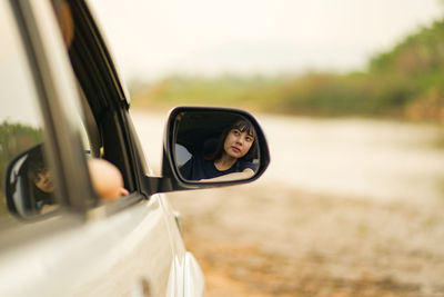 Portrait of man on side-view mirror