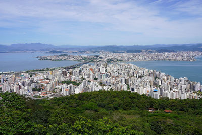 High angle view of townscape by sea against sky