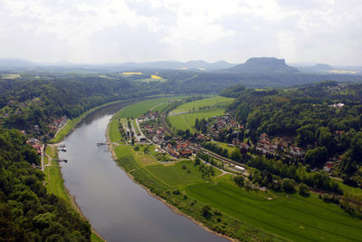 Scenic view of river amidst green landscape against sky