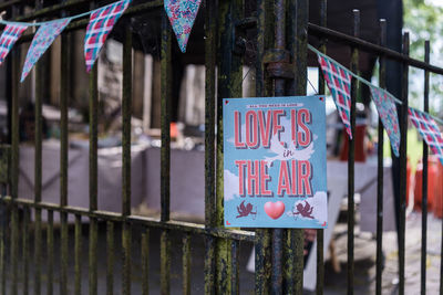 Close-up of information sign hanging on railing