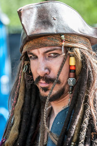 Close-up portrait of man with dreadlocks wearing hat
