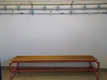 Empty bench on table against wall