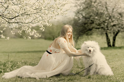Portrait of woman with dog on field