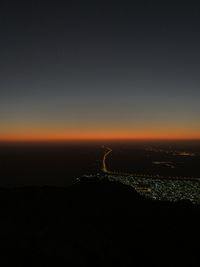 Silhouette city against sky at night