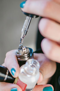 Close-up of woman holding electronic cigarette and dropper