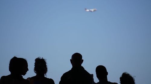 Silhouette people against clear sky