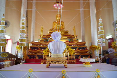 Statue against illuminated building in temple