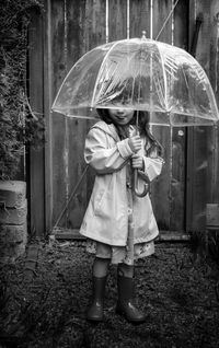 Full length of woman holding umbrella standing during rainy season