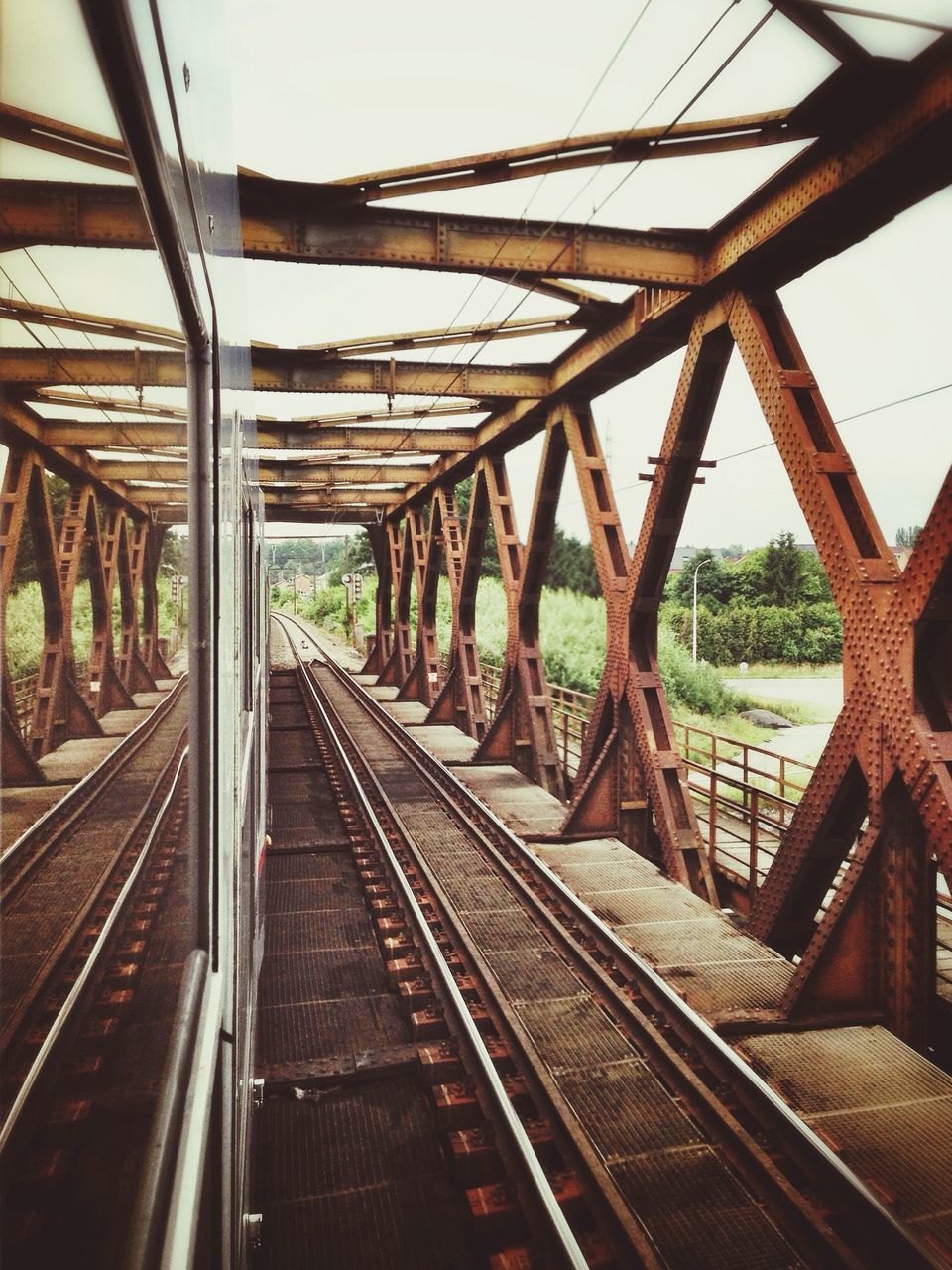 railroad track, rail transportation, transportation, diminishing perspective, the way forward, metal, connection, built structure, vanishing point, railway track, public transportation, sky, architecture, metallic, clear sky, day, no people, long, tree, bridge - man made structure