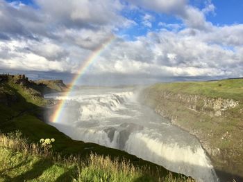 Scenic view of waterfall against sky