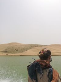 Rear view of woman against lake