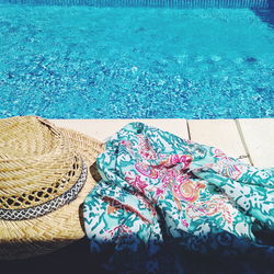 Close-up of sunhat and scarf by poolside