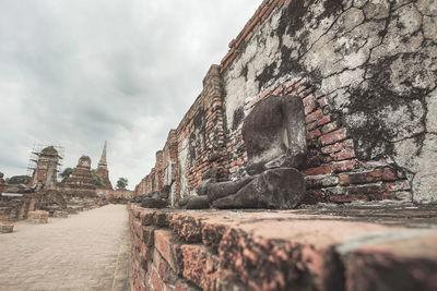 Low angle view of old building against cloudy sky