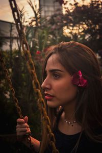 Portrait of young woman against plants