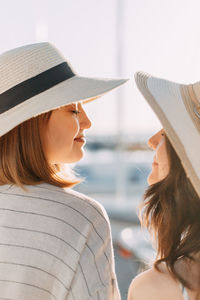 Portrait of two happy girls having a rest in hats at the sea