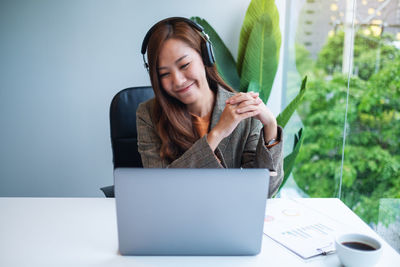 Portrait of young woman using laptop at home