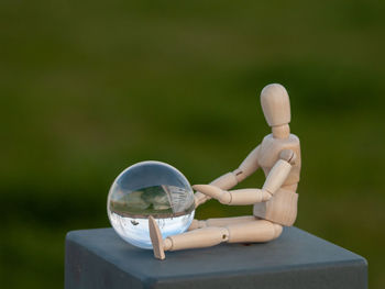 Close-up of crystal ball and figurine on retaining wall