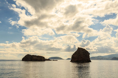 Scenic view of rocks in sea against sky