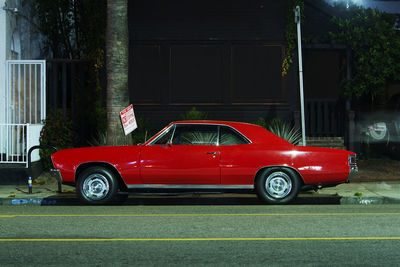 Side view of a classic vintage american muscle car in the street at night in venice, california