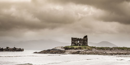 Built structure by sea against sky