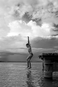 Full length of person jumping to sea against sky