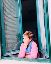 Portrait of woman sitting by window