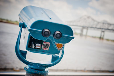 Close-up of coin-operated binoculars against sea