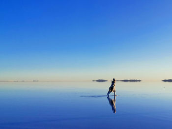 Man on beach against clear blue sky