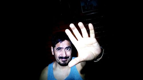 Close-up portrait of human hand against black background