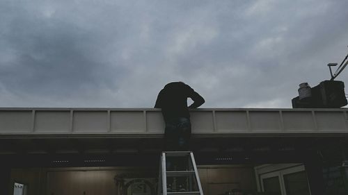 People standing against cloudy sky