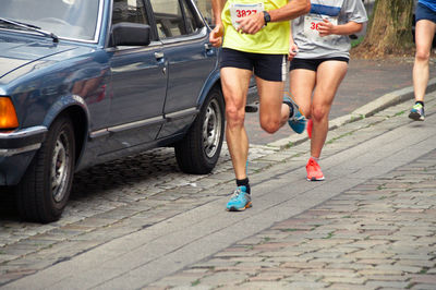 Low section of athletes running marathon on street