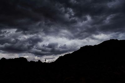 Silhouette of mountain against cloudy sky