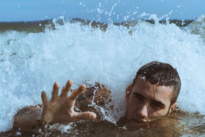 Portrait of young man swimming in sea