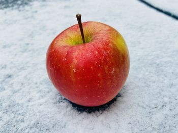 Red apple on snow background