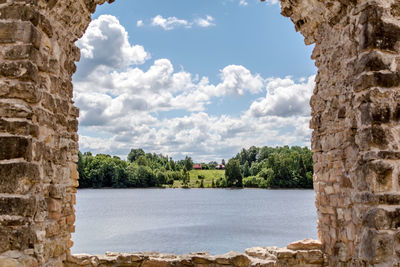 Scenic view of river by historic building against sky