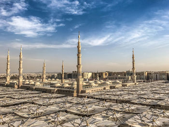 Buildings in city against cloudy sky