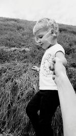 Rear view of girl on field against sky