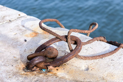 Close-up of rope tied to rusty anchor point
