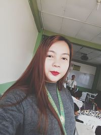 Portrait of beautiful young woman standing in classroom