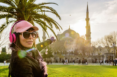 Portrait of smiling woman pointing at hagia sophia museum