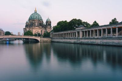 Arch bridge over river against buildings