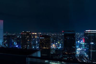 Illuminated buildings in city against sky at night