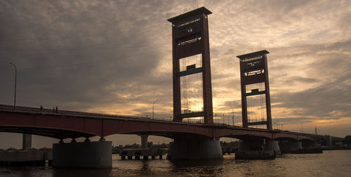 Low angle view of bridge over river against sky