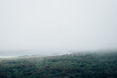 Scenic view of landscape against sky during foggy weather